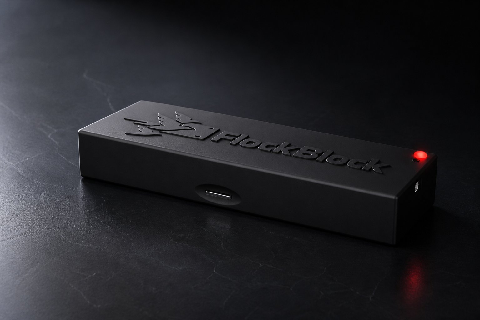 FlockBlock device from a low front angle on a dark surface